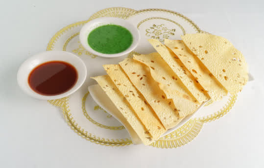 Papadum and breads served alongside an Indian catering buffet